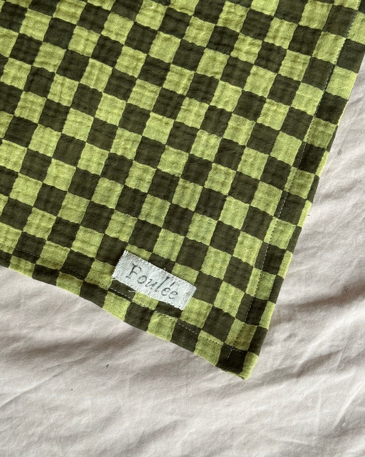 Gros plan d'un ourlet roulotté cousu main (détail textile)